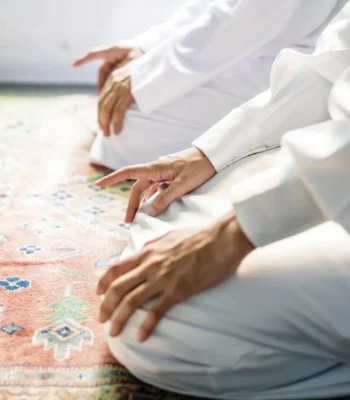 Muslim men praying in Tashahhud posture